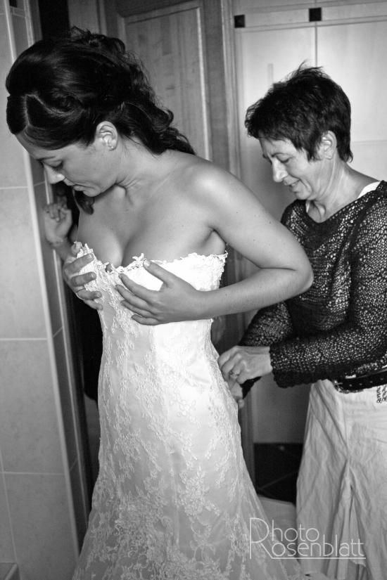 la mariée entrain de mettre sea robe