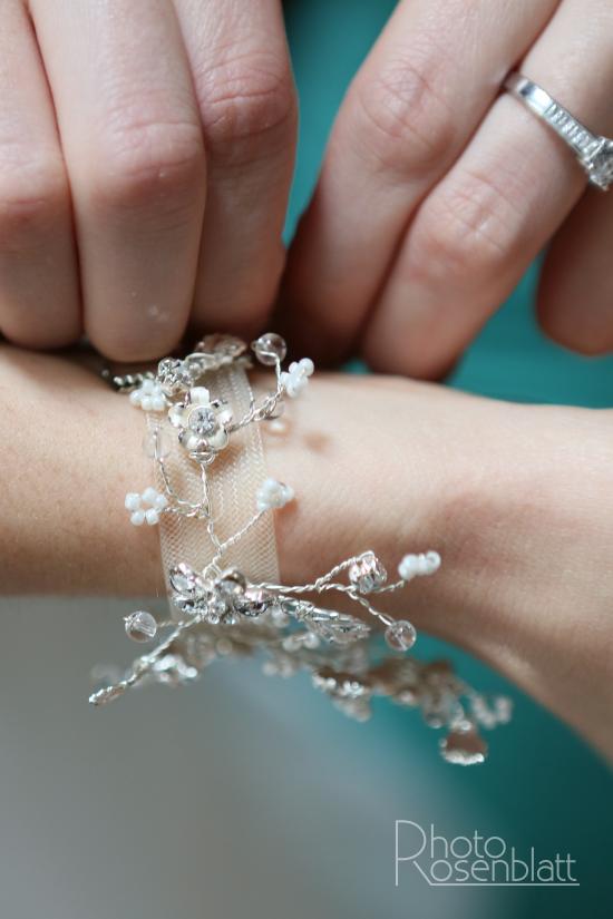 la mariée surprise entrain de mettre un bracelet